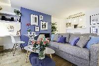 comfortable grey sofa bed and center table in a 1-bedroom Paris luxury apartment