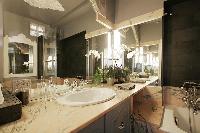 elegant bathroom with a sink, a mirror, a toilet, and a bathtub with a detachable shower head in a 1