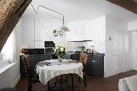 classy dining area with a table for two and exposed beam in a 1-bedroom Paris luxury apartment