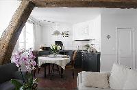 classy dining area with a table for two and exposed beam in a 1-bedroom Paris luxury apartment