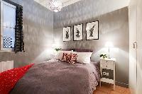 bedroom with built-in cabinets, two bedside tables with lamps, and a double bed 1-bedroom Paris luxu