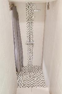 sleek bathroom with a shower area with a detachable shower head in a 1-bedroom Paris luxury apartmen