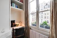 cozy living area with a small workstation in a 1-bedroom Paris luxury apartment