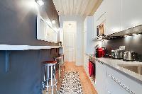 a long and sleek kitchen in a 1-bedroom Paris luxury apartment
