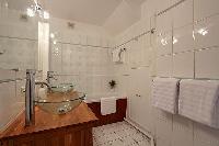 bathroom with double sinks, a bathroom cabinet, and a bathtub in a 2-bedroom Paris luxury apartment