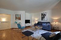 modern dining and living area in blue and white hues with bright windows dressed with drape curtains