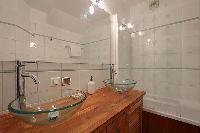 bathroom with double sinks, a bathroom cabinet, and a bathtub in a 2-bedroom Paris luxury apartment