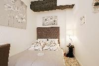 first bedroom with a double bed, a nightstand, and a bedside table with lamp in a 2-bedroom Paris lu