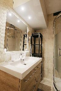 sleek bathroom with a toilet, a sink, a bathroom cabinet, a towel rack, and a shower enclosure in a 