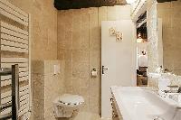 sleek bathroom with a toilet, a sink, a bathroom cabinet, a towel rack, and a shower enclosure in a 