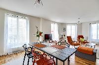 modern kitchen and dining area with dining table and chairs in grey and apricot hues in a 2-bedroom 