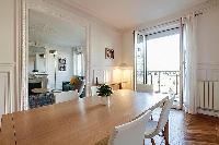 chic dining set for six with French window and access to the living area in a 2-bedroom paris luxury