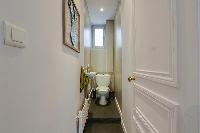 a separate toilet and sink in the water closet of a 2-bedroom paris luxury apartment