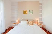 chic master bedroom is furnished with a queen-size bed, two bedside tables, built-in shelves, and Fr