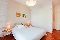 chic master bedroom is furnished with a queen-size bed, two bedside tables, built-in shelves, and Fr