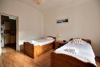 second bedroom is equipped with two single beds, a wardrobe, and a chest of drawers in a 2-bedroom P