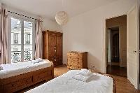 second bedroom is equipped with two single beds, a wardrobe, and a chest of drawers in a 2-bedroom P