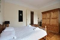 first bedroom with an en-suite bathroom furnished with double sinks, a bathroom cabinet, mirrors, an