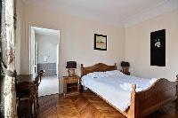first bedroom with an en-suite bathroom furnished with double sinks, a bathroom cabinet, mirrors, an