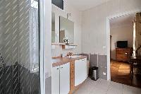 an en-suite bathroom with a sink, a bathroom cabinet, a mirror, and a shower area in a 2-bedroom Par