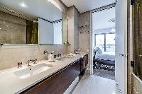 en-suite bathroom fully-furnished with a sink, a bathtub, a bathroom cabinet, a toilet, and bidet