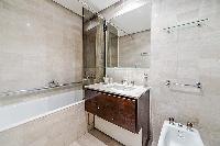 en-suite bathroom fully-furnished with a sink, a bathtub, a bathroom cabinet, a toilet, and bidet