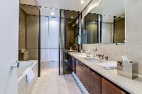 en-suite bathroom fully-furnished with a sink, a bathtub, a bathroom cabinet, a toilet, and bidet
