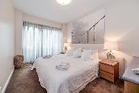 fourth bedroom furnished with a queen-size bed, two bedside tables with lamps, a nightstand, and Fre
