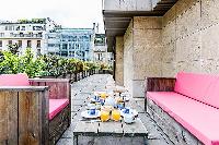 terrace with pieces of patio furniture in a 4-bedroom paris luxury apartment