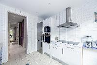 spacious blue and white kitchen situated near the terrace