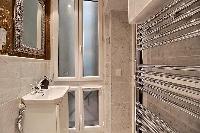 en-suite bathroom fully-furnished with double sinks, a bathroom cabinet, a toilet, and a shower area