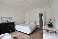 bedroom three with queen size bed and cabinet drawers in a Paris luxury apartment