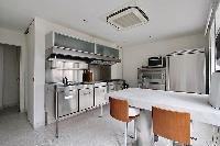 cozy kitchen with white breakfast bar and stools in Paris luxury apartment