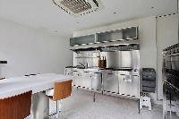 cozy kitchen with white breakfast bar and stools in Paris luxury apartment