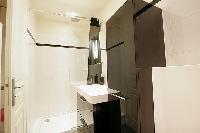 well-designed bathroom with shower, sink and toilet in a 1-bedroom Paris luxury apartment