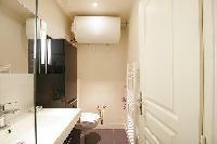 well-designed bathroom with shower, sink and toilet in a 1-bedroom Paris luxury apartment