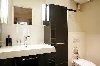 well-designed bathroom with shower, sink and toilet in a 1-bedroom Paris luxury apartment