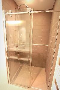a rainfall showerhead and detachable shower head in a 2-bedroom Paris luxury apartment