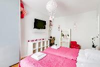 chic bedroom with two single beds joined together to form a queen-size bed, shelves, a study corner,