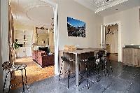 tall wooden table and stools in a 3-bedroom Paris luxury apartment