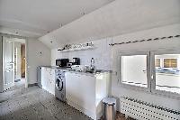 space-efficient kitchen and a washing machine in a 2-bedroom Paris luxury apartment