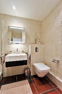 an en-suite bathroom fully-furnished with a sink, a toilet, a mirror, and a shower area  in a 2-bedr