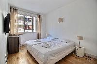 second bedroom with two single beds joined together, a television, and a nightstand in Paris luxury