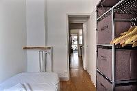 third bedroom with a single bed, a bedside table, and shelves with pull out baskets in Paris luxury