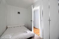 third bedroom with closets and a sofa that folds out into a double bed in a 3-bedroom Paris luxury a