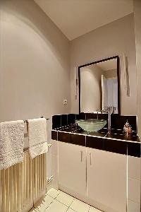 modern bathroom with a bathtub, shower and sink in a 3-bedroom Paris luxury apartment