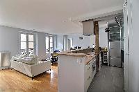 a large and open kitchen, living and dining area in a 3-bedroom Paris luxury apartment