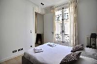 bedroom with a queen size bed in a 2-bedroom Paris luxury apartment