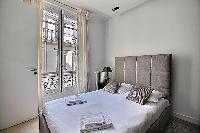 bedroom with a queen size bed in a 2-bedroom Paris luxury apartment