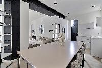 a dining table seats up to six guests in a 2-bedroom Paris luxury apartment